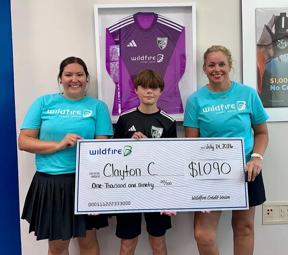 Wildfire employees hold check with Midland Fusion's soccer player recipient.