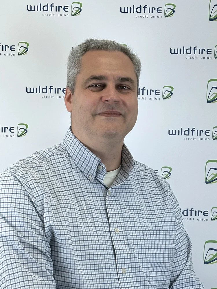 Headshot of employee Troy Del Valle on Wildfire backdrop.