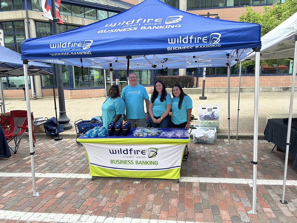 Four Wildfire employees under tent handing out trinkets for Business Banking.
