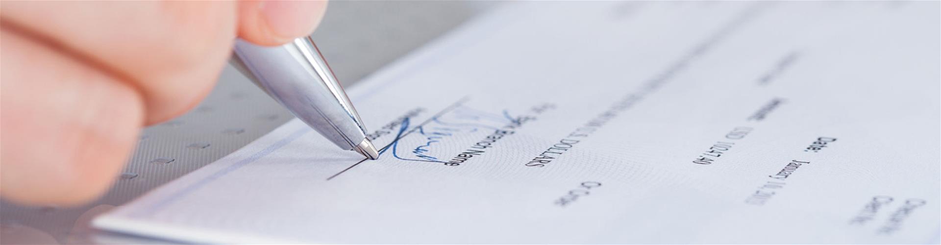 Person signing a check Person signing a check
