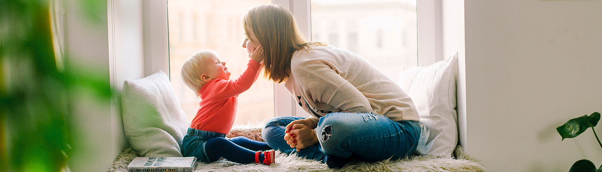 Baby Touching Woman's Face at home by a window