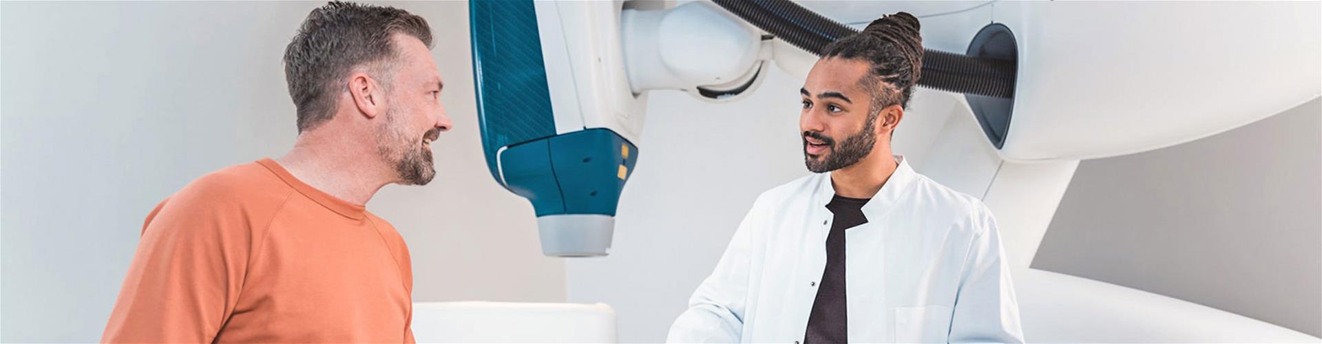 Male doctor happily talking to male patient Male doctor happily talking to male patient