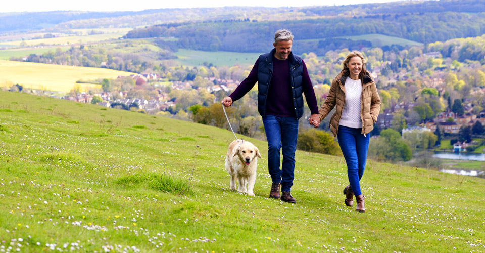 Middle aged couple taking a walk with dog