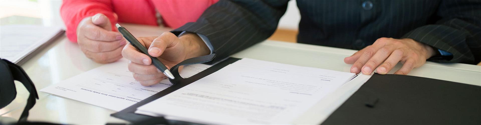 person holding a pen near a piece of paper person holding a pen near a piece of paper