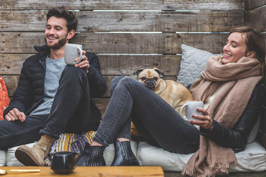 Man and woman happily enjoying home with their dog