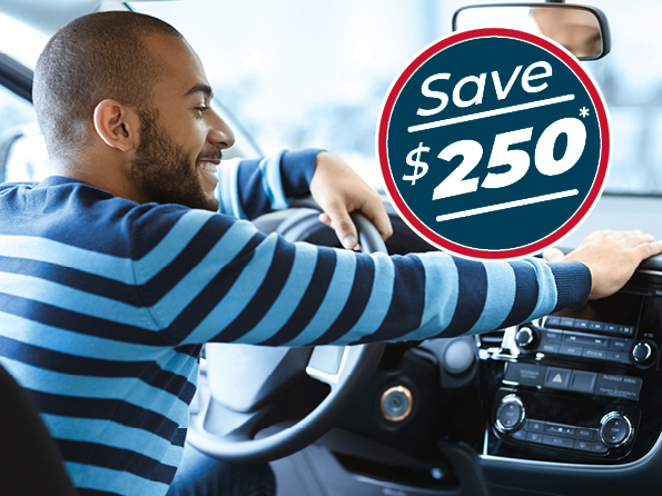 Gentleman sitting in his car smiling that he saved $250 off his first consumer loan payment.