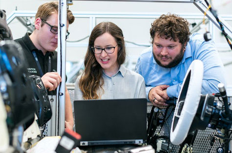Engineering team happily working on computer Engineering team happily working on computer