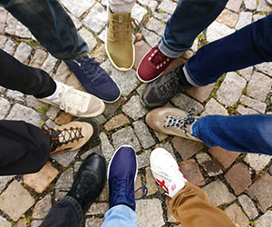 People standing in circle with their feet in the middle People standing in circle with their feet in the middle