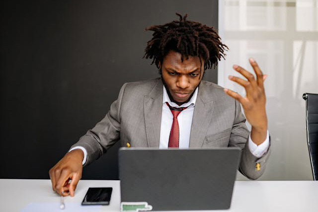 Frustrated business man working on a laptop in an office