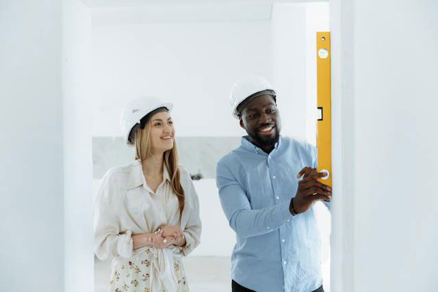 Happy couple working in their home use a level to work on a home remodel