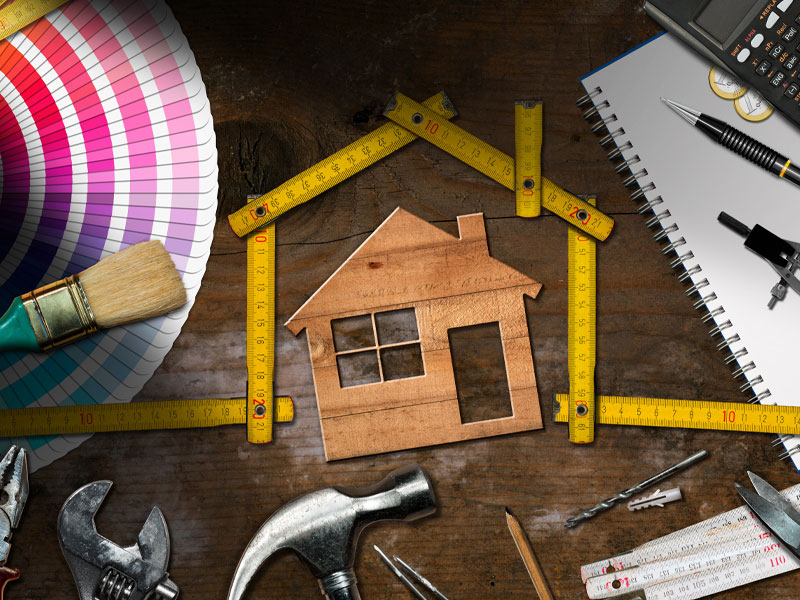 Image of a house with a tape measure and other tools