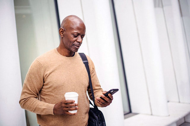 man with smartphone and coffee