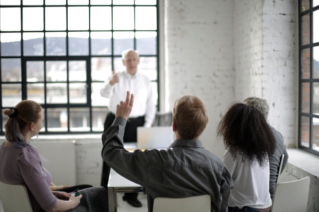 People having a meeting with one person raising their hand