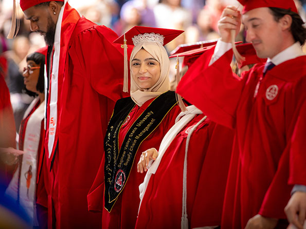 SVSU Graduates at a graduation ceremony wearing red gowns and caps