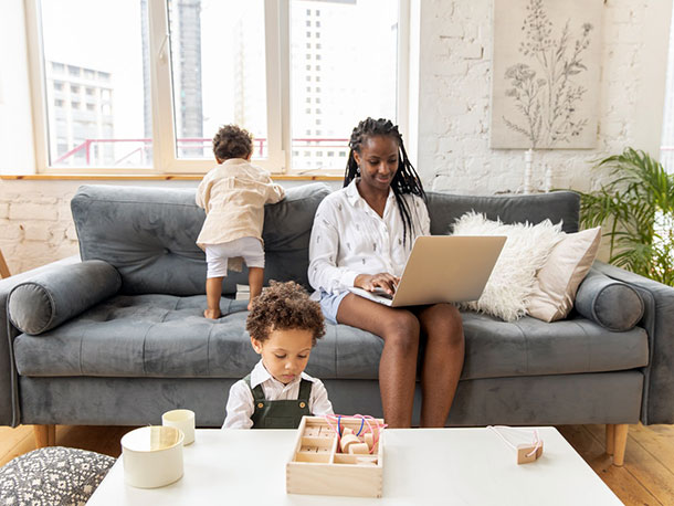 Woman with laptop Sitting on Gray Couch With 2 Children