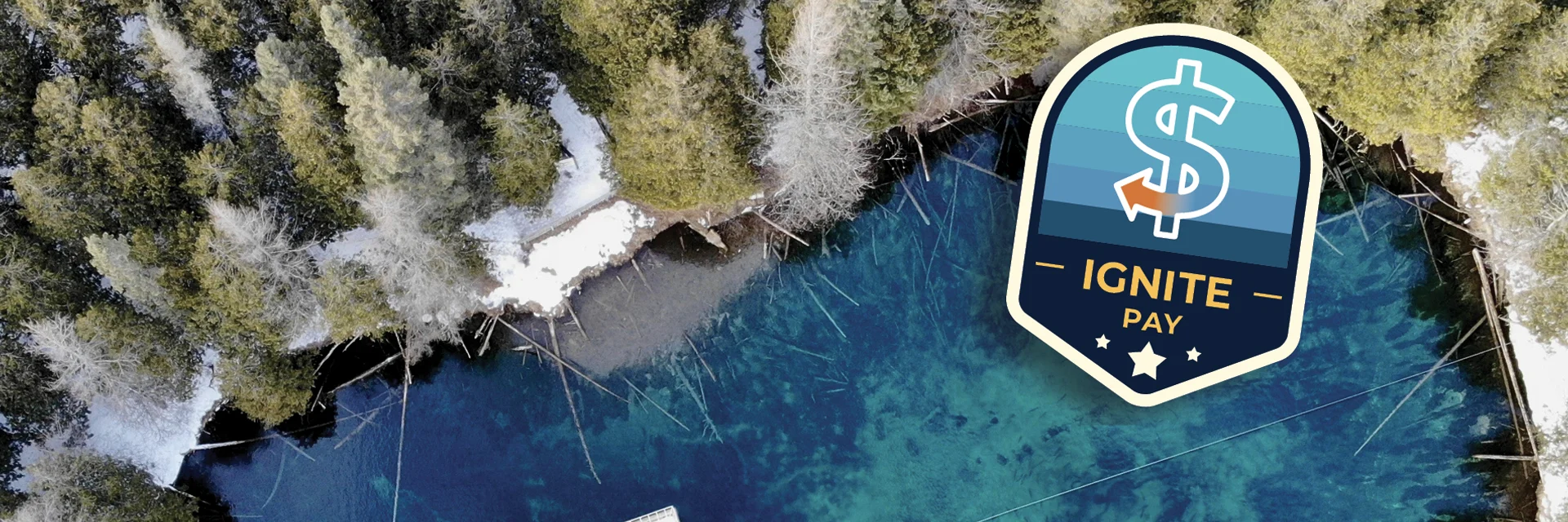 Ignite Pay badge displayed over an aerial photo of Kitch-iti-kipi in the winter of the Upper Peninsula.