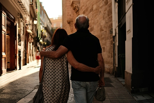 couple walking downtown in historic city arm in arm.