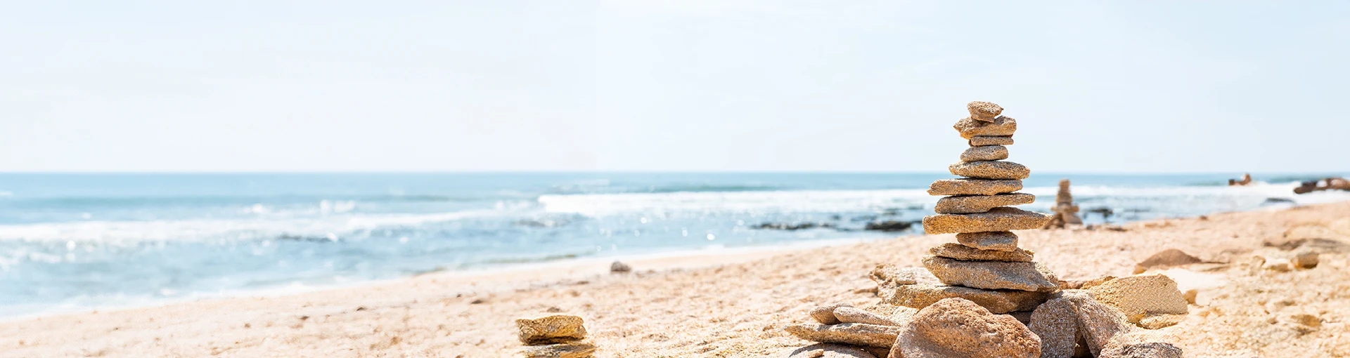 Stack of rocks made into a tower on a sunny day at Lake Huron beach.