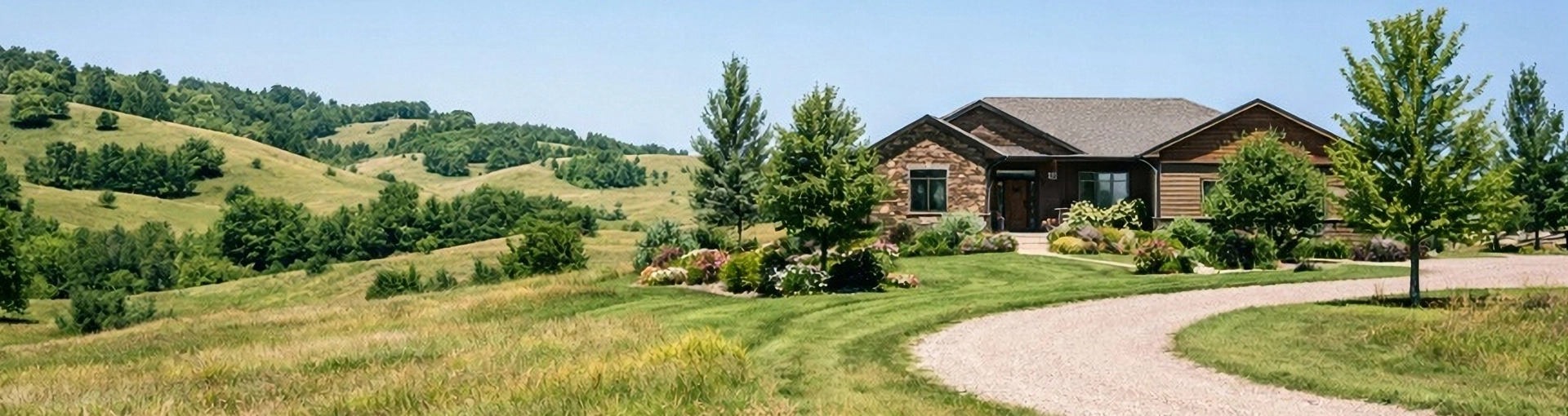 Brown brick home in the country with rolling hills and land around it.