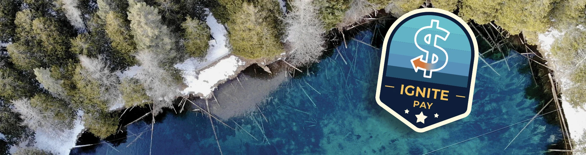Ignite Pay badge displayed over an aerial photo of Kitch-iti-kipi in the winter of the Upper Peninsula.