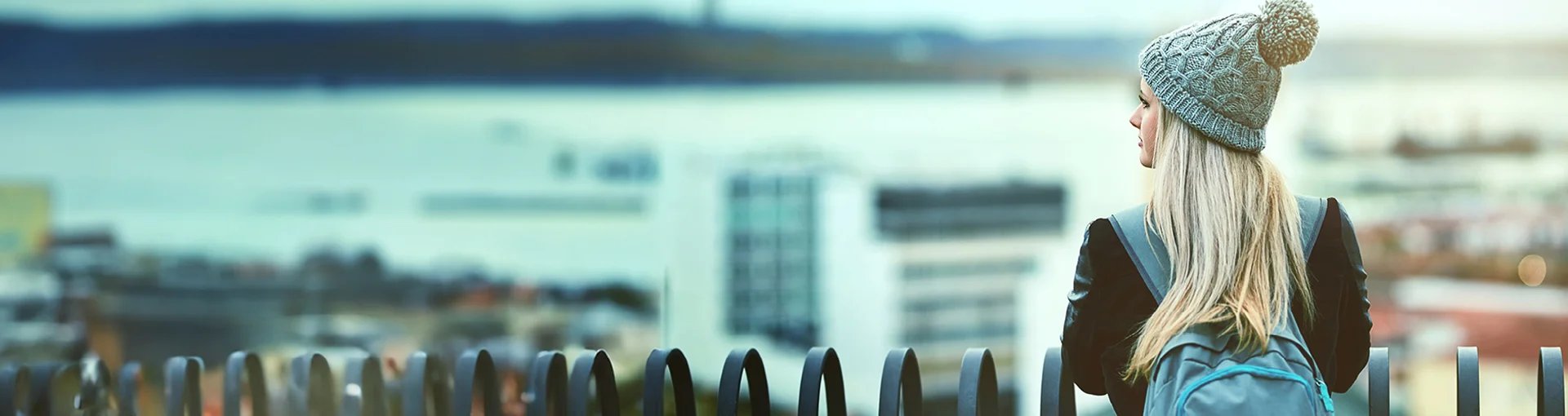 College student waiting for bus outside in the winter.