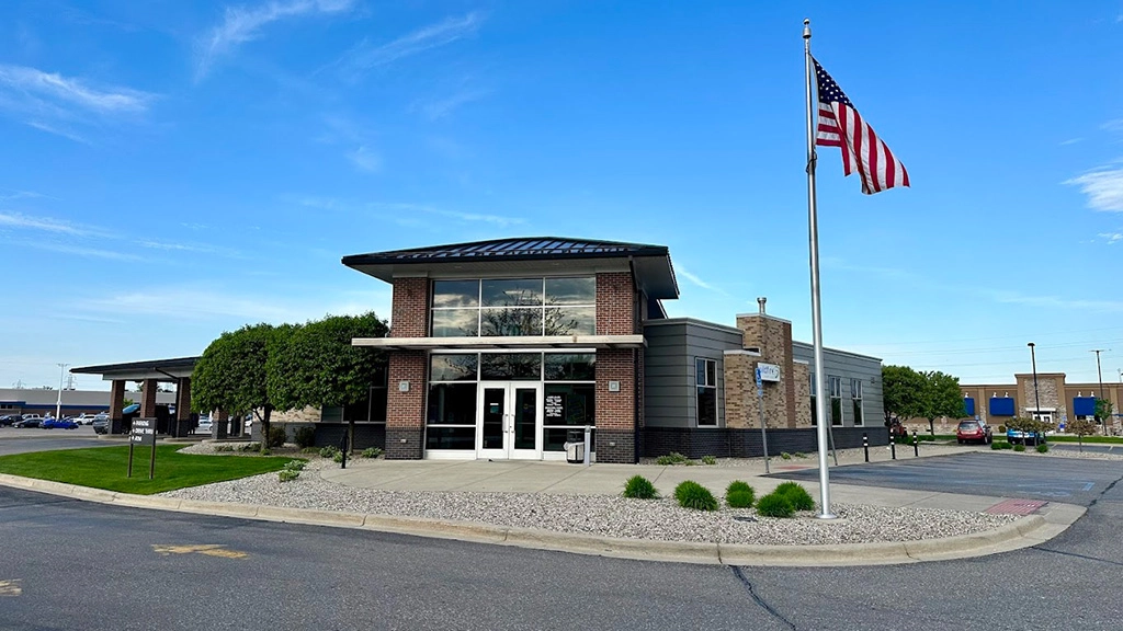 Bay City office on a beautiful blue sky day with american flag blowing in wind.