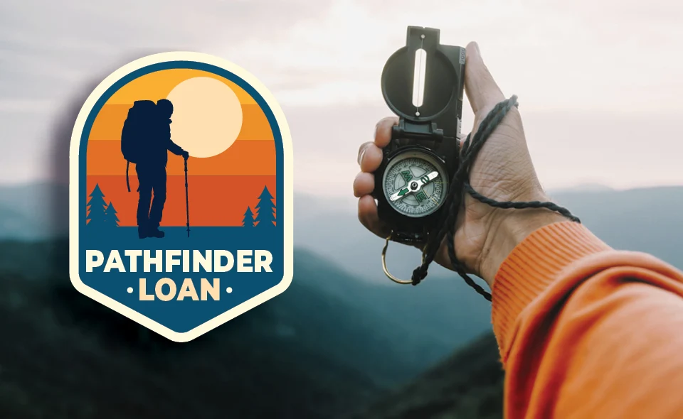 Pathfinder Loan badge and trail compass held over mountains with cloud haze.