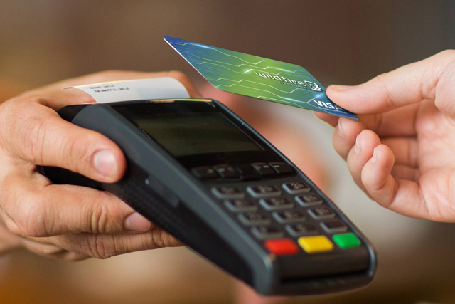 Business Debit Card Person paying with a Wildfire business debit card