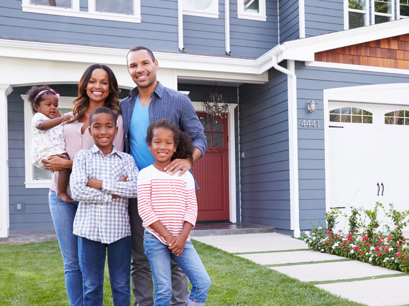 Family posing outside new home