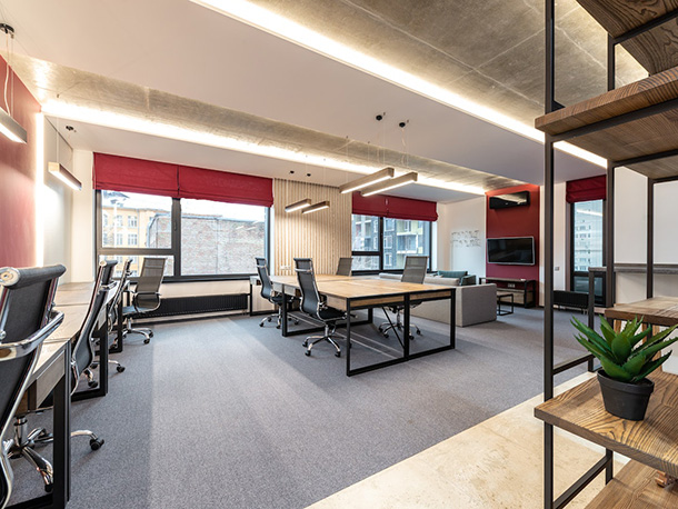 empty office with chairs, table, tv near windows