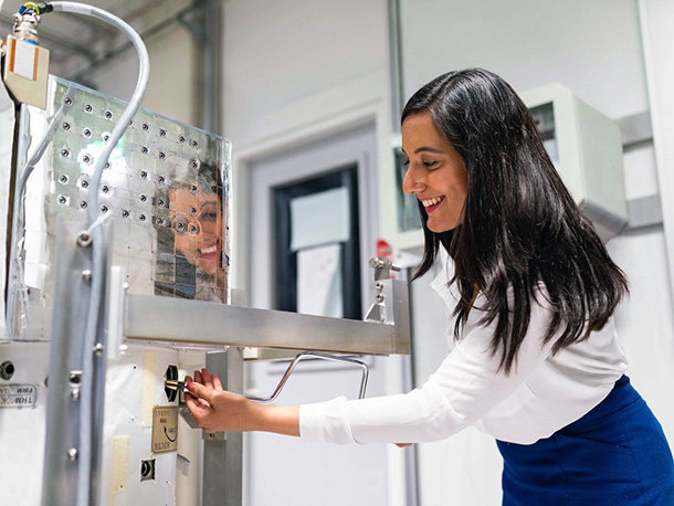 Happy Female Engineer with equipment in lab Happy Female Engineer with equipment in lab