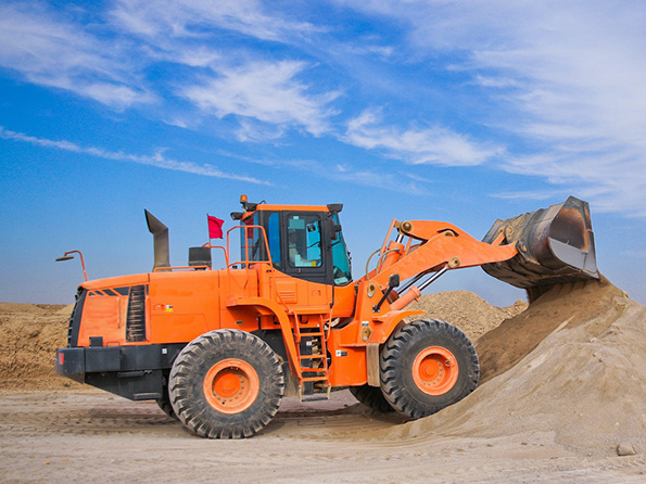 orange excavator shoveling sand
