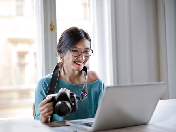 cheerful female photographer working on a laptop