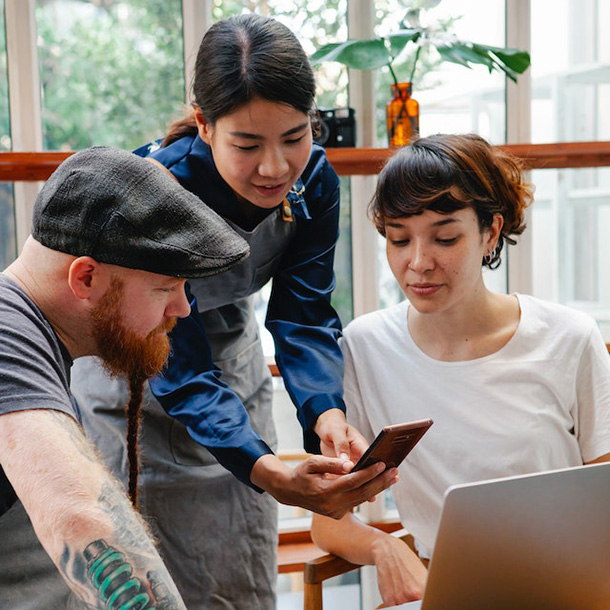 co-workers looking at smartphone