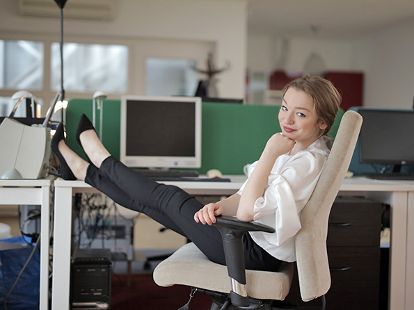 Smiling employee with feet on desk