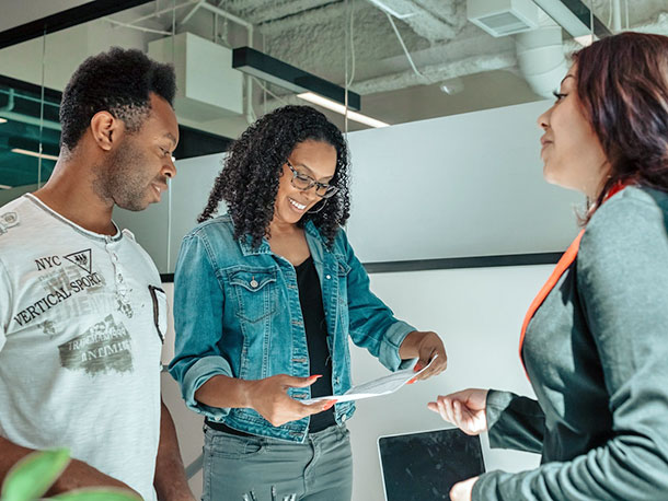 Business Woman and two clients happily looking over document Business Woman and two clients happily looking over document