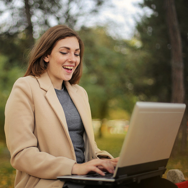 Excited Woman Using Computer Laptop outside
