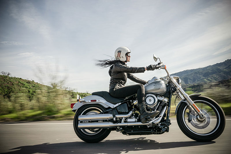 Female on motorcycle speeding down open highway on partly cloudy day Female on motorcycle speeding down open highway on partly cloudy day