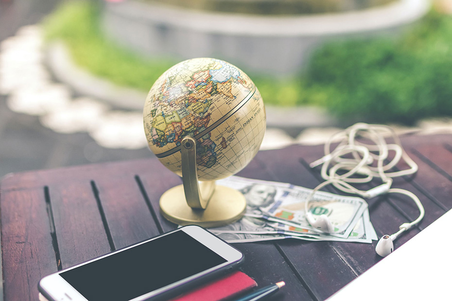 Mini globe outside on table with money