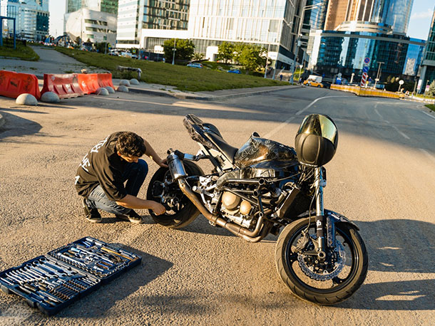 Man fixing his motorcycle Man fixing his motorcycle