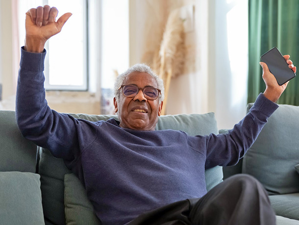 excited elderly man holding a smartphone