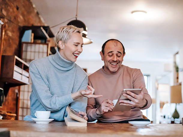 Joyful multiracial middle aged couple using a tablet Joyful multiracial middle aged couple using a tablet