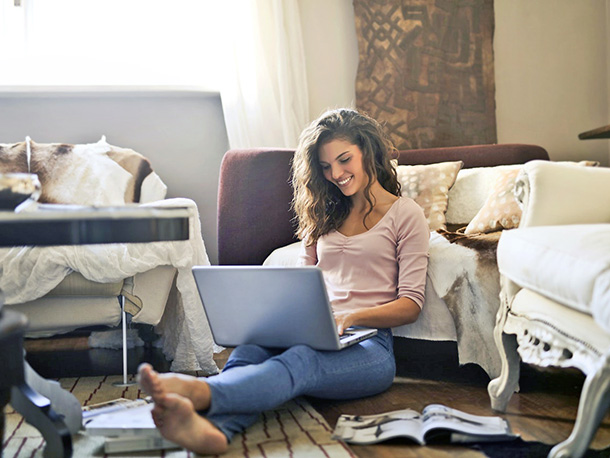 Woman smiling while using laptop in living room