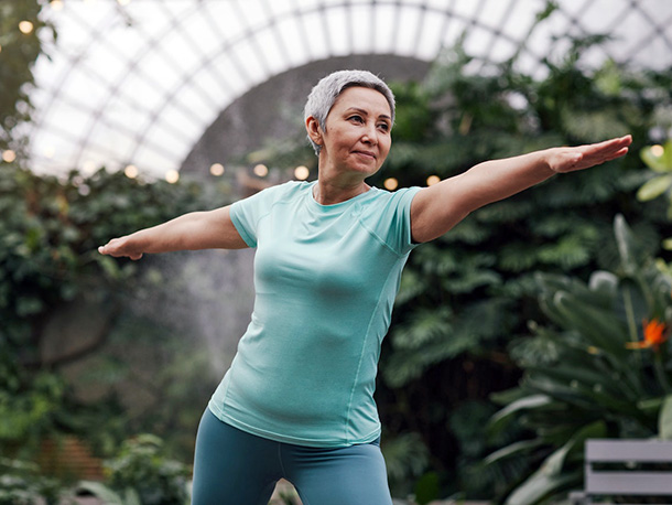 Woman doing yoga in indoor garden Woman doing yoga in indoor garden