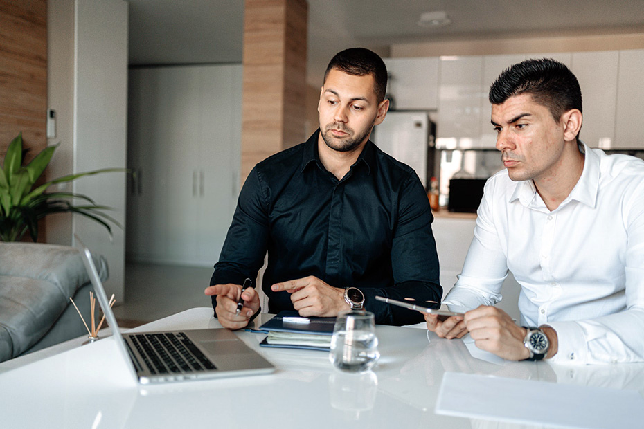 Two men working diligently on a computer