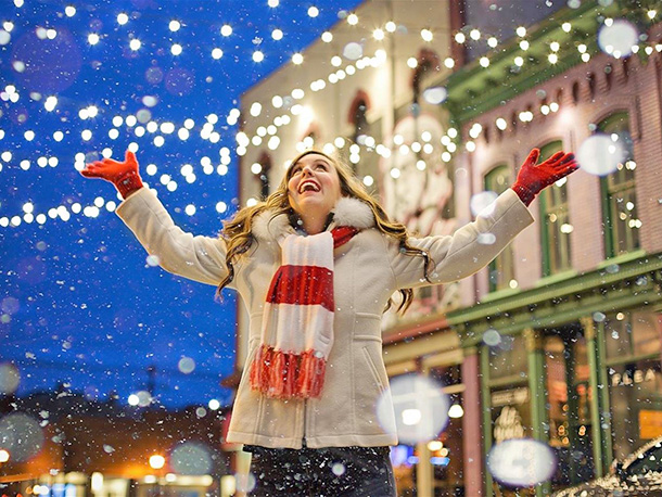Female joyfully celebrating in city street at night during winter