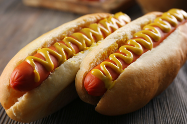 Hotdog days Two hot dogs with mustard on them