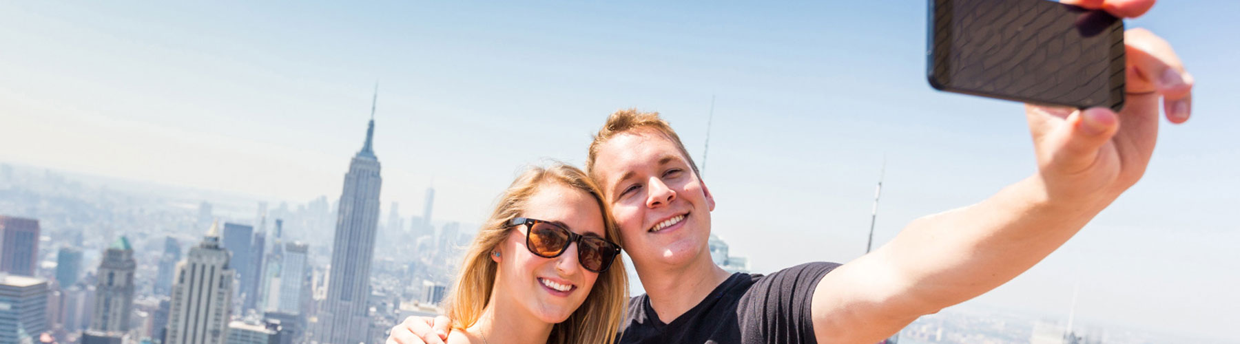 Happy Couple taking a selfie on top of a skyscraper