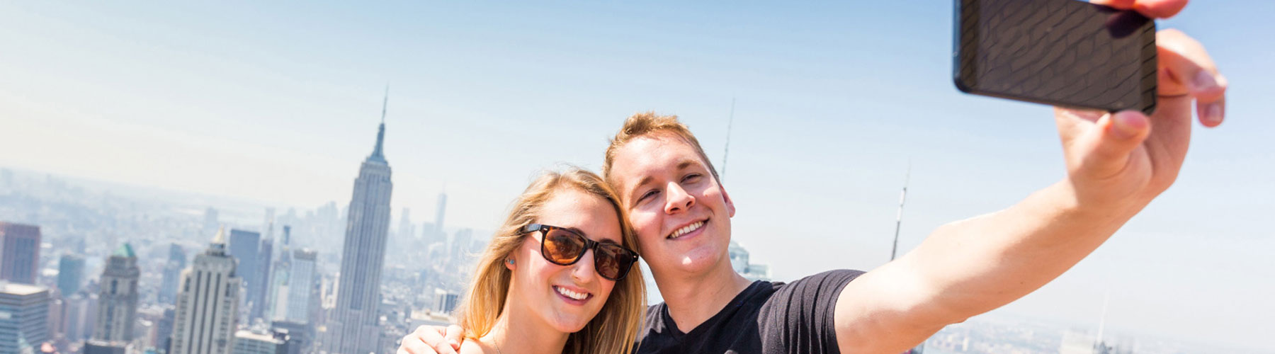 Couple taking selfie with skyline in background Couple taking selfie with skyline in background