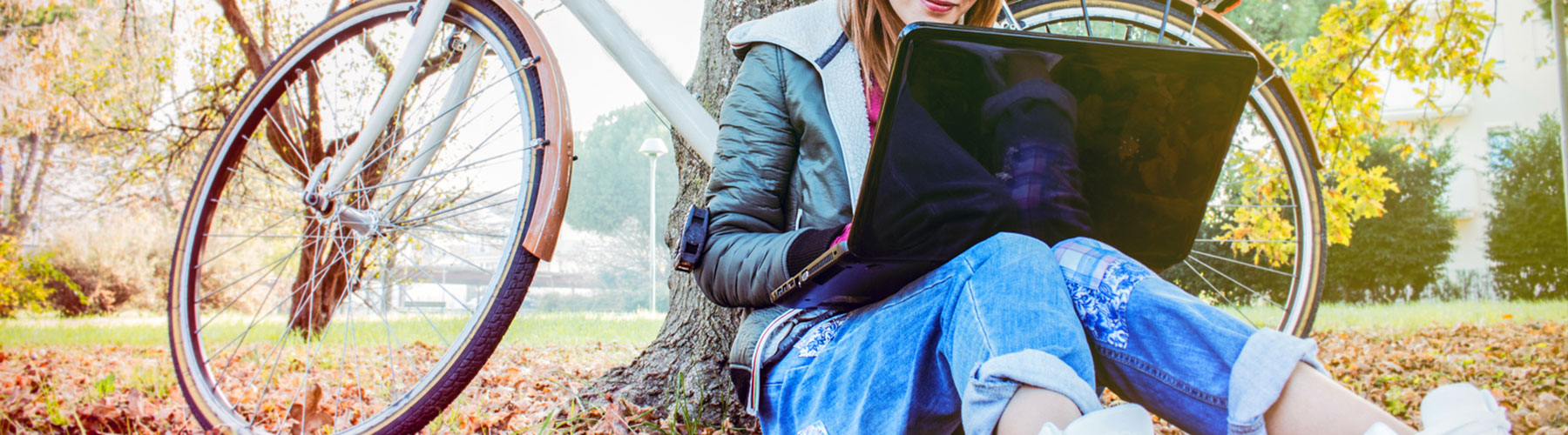 Female sitting down outside on laptop during Fall